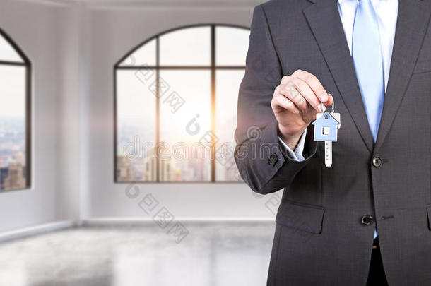 穿着正式西装的人在现代阁楼全景公寓或办公室里拿着钥匙。 租或买新房子或办公室。 纽约风景。 a