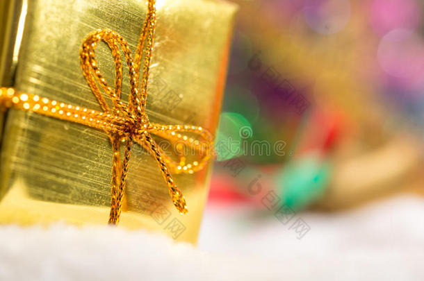 圣诞背景与雪地中的bokeh和<strong>金色礼品</strong>盒