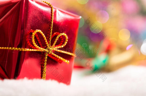 圣诞背景与雪地中的bokeh和红色礼品盒