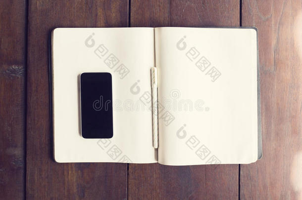 空白智能手机桌面上的空白页日记与笔