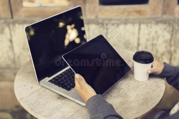 带纸杯咖啡、数码平板电脑和笔记本电脑的女孩