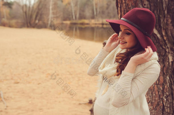 美丽的<strong>孕妇</strong>戴着时尚的帽子在舒适<strong>温暖</strong>的户外散步