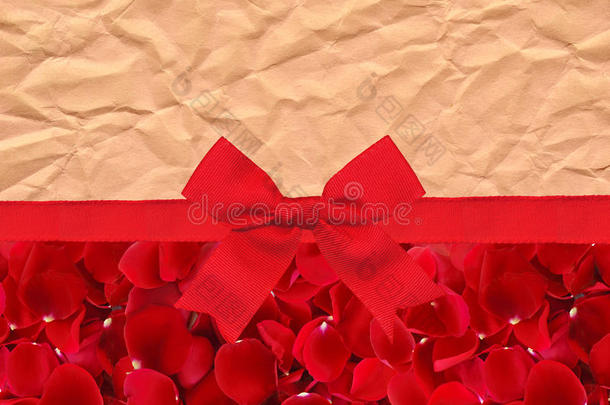美丽的红色玫瑰花瓣和红色丝带，在旧纸上鞠躬