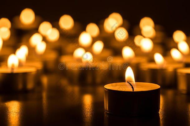 圣诞蜡烛在晚上燃烧。 抽象蜡烛背景。 蜡烛火焰的金光。