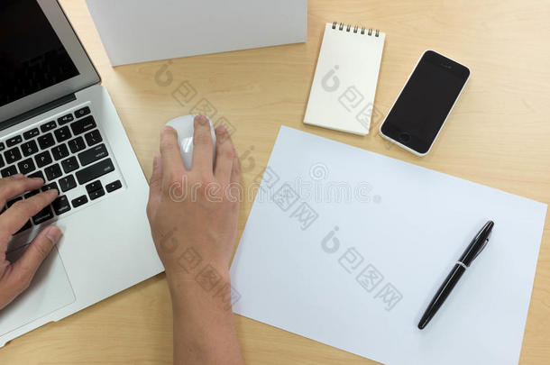 人的手使用笔记本电脑与智能手机，平板电脑，钢笔，日历和一张纸