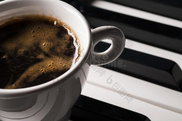 钢琴键盘上的咖啡杯