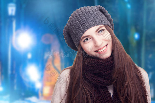 冬天背景上戴着舒适衣服帽子的女孩