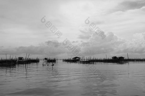黑白色调的家庭和浮动篮子在湖在高霍，松赫拉，泰国美丽的天空和云。 这是T