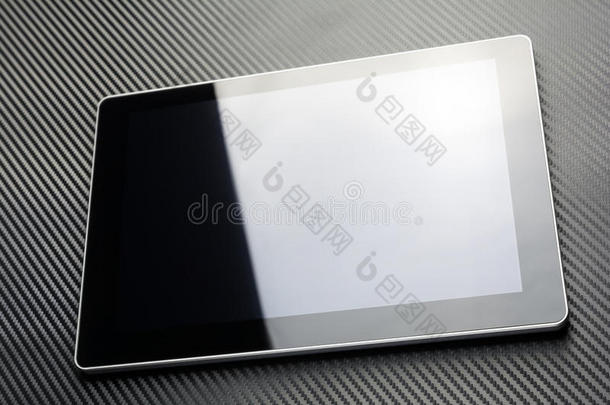 空白的商业平板电脑，反射在碳背景上