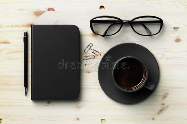 黑色空白日记封面，黑色咖啡杯和木头上的眼镜