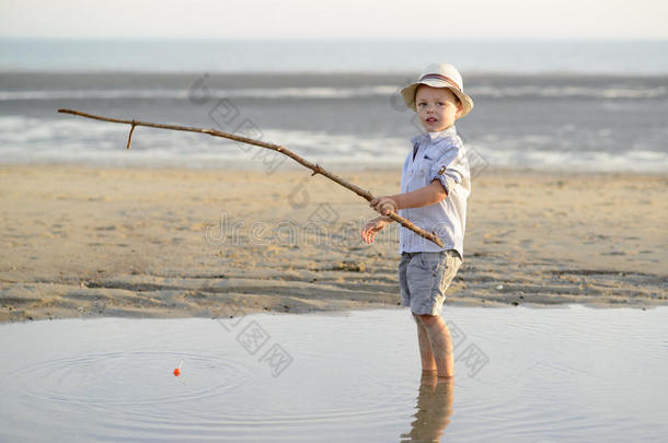 孩子正在海边的海滩上钓鱼