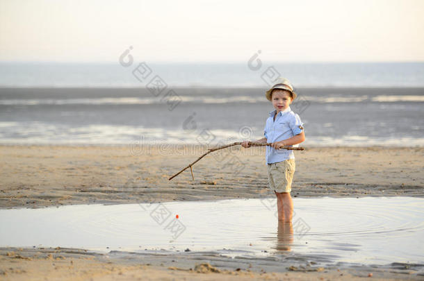 孩子正在海边的海滩上钓鱼