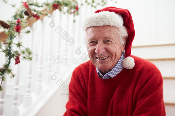 圣诞老人戴着圣诞老人的帽子坐在楼梯上