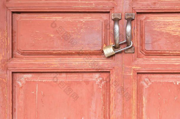 旧红色木门上的黄铜锁