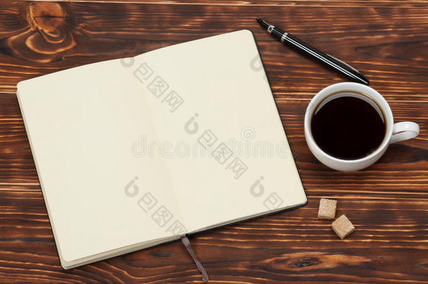 空白打开记事本。 一杯咖啡。 木制的