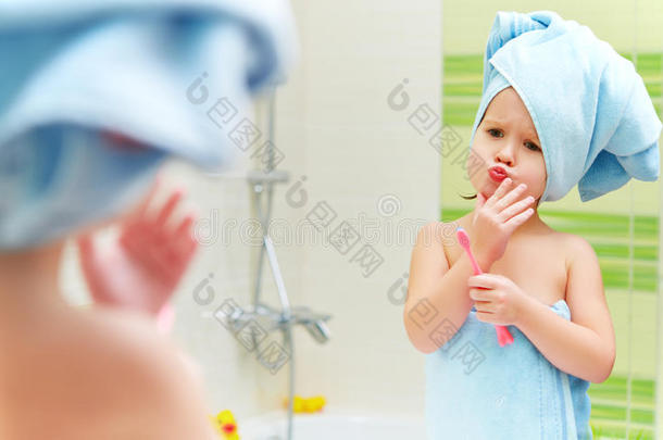 有趣的小女孩在浴室用牙刷清洁牙齿