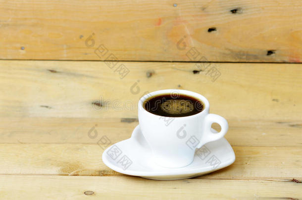 木制桌子上的白色杯子里的咖啡