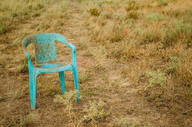 肮脏的<strong>复古</strong>损坏的塑料绿色<strong>椅子</strong>被遗弃在田野里