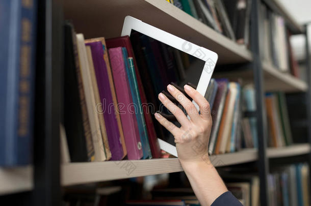 从图书馆的书架上用手挑选的平板电脑
