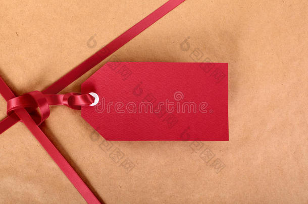 特写<strong>红色礼品</strong>标签和丝带，棕色包裹包装纸<strong>背景</strong>