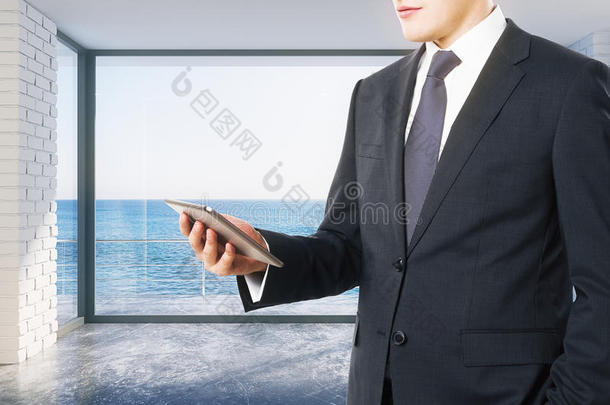 商家在海景空旷的阁楼房里看数字平板