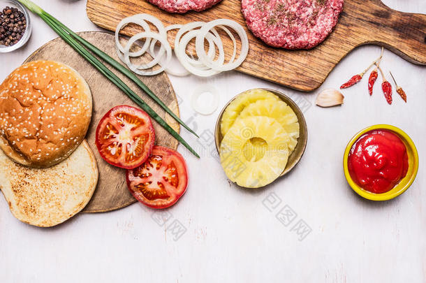 烹饪汉堡概念包子，切碎的肉，洋葱，西红柿，酱汁边框，放置文字在木制乡村背景