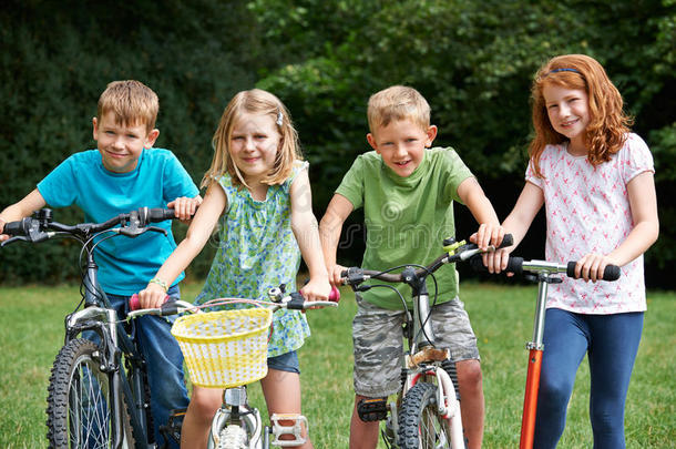 一群孩子骑自行车和滑板车玩