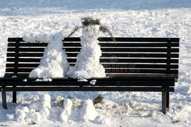 2012年意大利，雪人在公园长椅上融化在阳光下