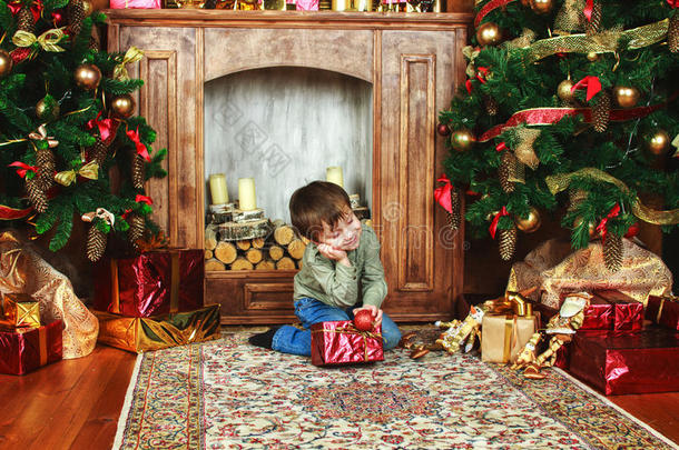 孩子坐在圣诞树下拿着礼物