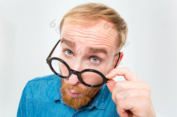 有趣的年轻人留着胡子，看着黑色的圆形眼镜