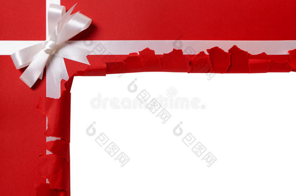 圣诞礼物<strong><strong>撕</strong>开</strong>揭示复制空间内，白色丝带蝴蝶结，红色包装纸背景