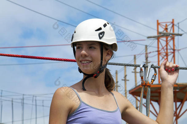 在绳子冒险公园，一个年轻的女人<strong>回头</strong>看