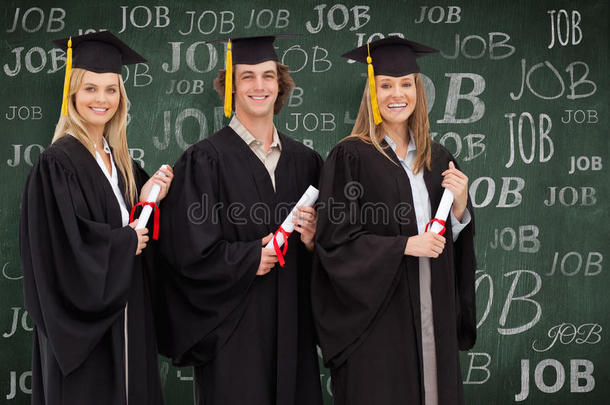 三个微笑的学生穿着研究生长袍拿着文凭的复合<strong>形象</strong>