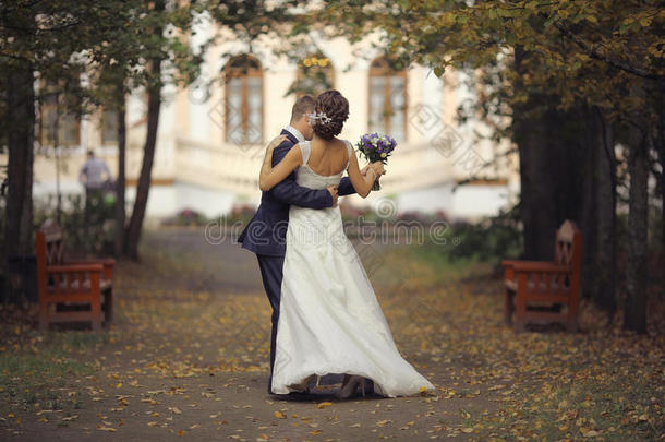 新娘和新郎在秋天的公园拥抱