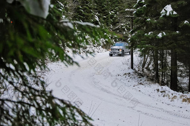 在森林的冬季雪路上漂流的4x4卡车