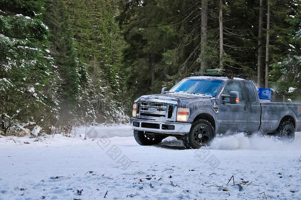在森林的冬季雪路上漂流的4x4卡车