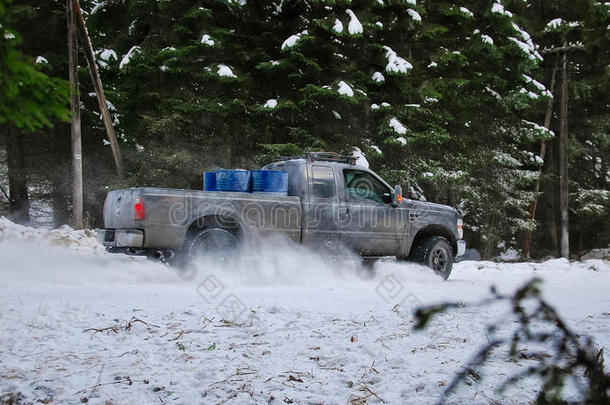 在森林的冬季雪路上漂流的4x4卡车