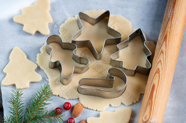 烤圣诞饼干-桌子上的面团，饼干切割机和饼干