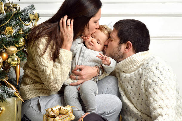 圣诞家庭带着孩子和黄金礼物。 快乐的接吻
