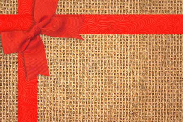 麻布纹理背景与红色丝带和蝴蝶结