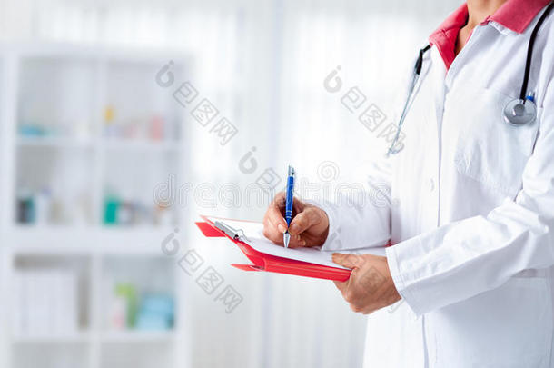 医生用听诊器在医院的纸板上写字
