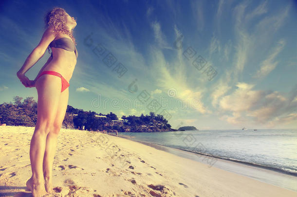 带金色卷发的女孩在海滩上休息