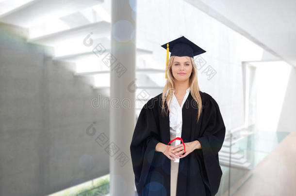 穿着研究生长袍的金发学生拿着她的文凭的综合<strong>形象</strong>