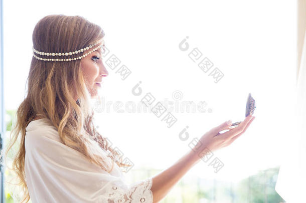 美丽的年轻新娘穿着白色连衣裙和镜子。 婚礼的最后准备。 新娘在等她的新郎。 早上好，TH