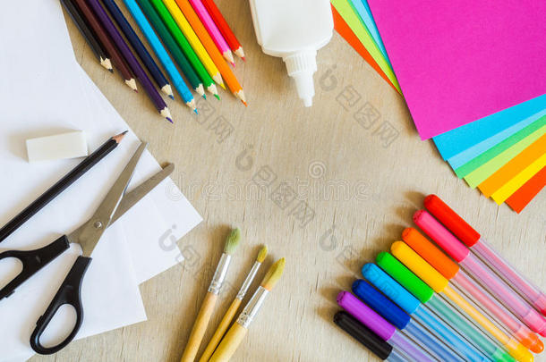 彩色纸，毛毡尖笔，铅笔，木制背景上的刷子
