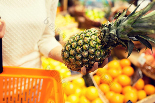 在杂货店市场上关闭带菠萝的女人