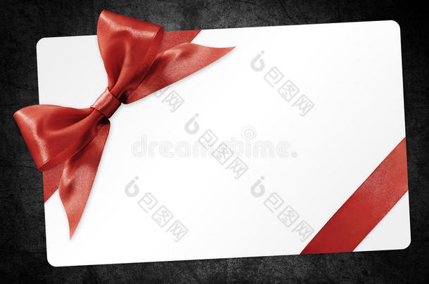 礼品卡与红色丝带蝴蝶结隔离在黑色背景上