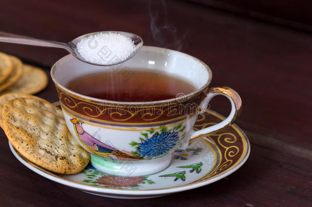 古色古香的茶杯，满是茶和糖，还有放在木<strong>制茶</strong>壶上的饼干