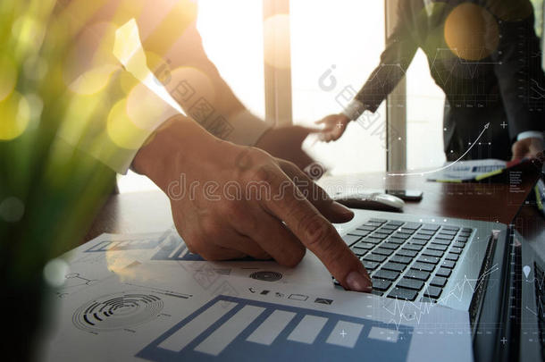 在办公桌上双曝光商业文件，配有现代笔记本电脑和数字商业战略图和两个c