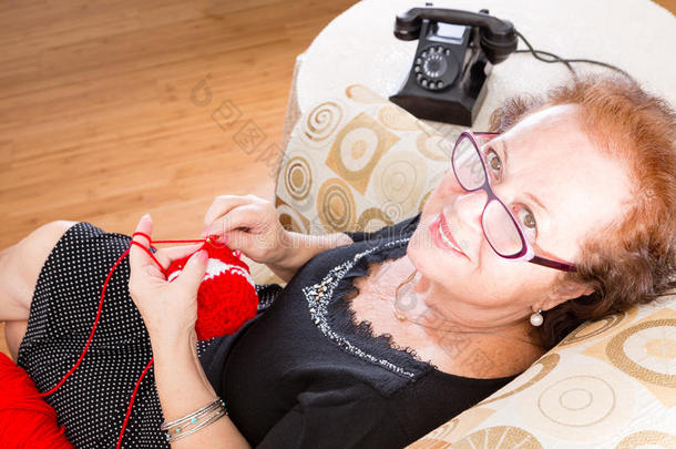 年迈的祖母坐在椅子上编织